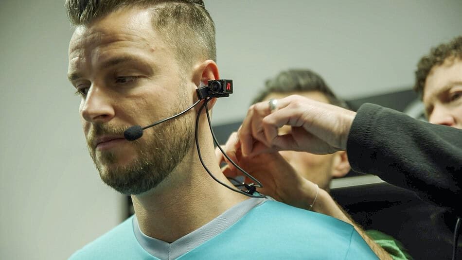 A referee being fitted with a small RED body camera mounted on their headset